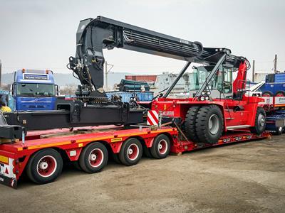 Lowbed semi-trailer with an optimized loading length for the transport of container handling machines.