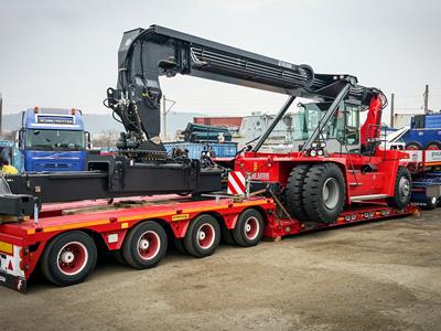 Semirimorchio basso con una lunghezza di carico ottimizzata per il trasporto di macchine per la movimentazione di container.