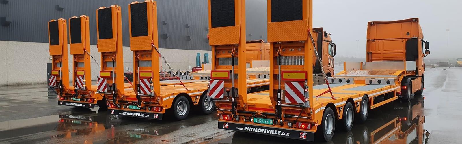 Die in orange lackierten Semis sind ein echter Blickfang, wenn Fräsen und Zubehör für Straßenbauprojekte quer durch das Land bewegt werden.