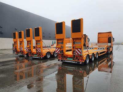 Die in orange lackierten Semis sind ein echter Blickfang, wenn Fräsen und Zubehör für Straßenbauprojekte quer durch das Land bewegt werden.